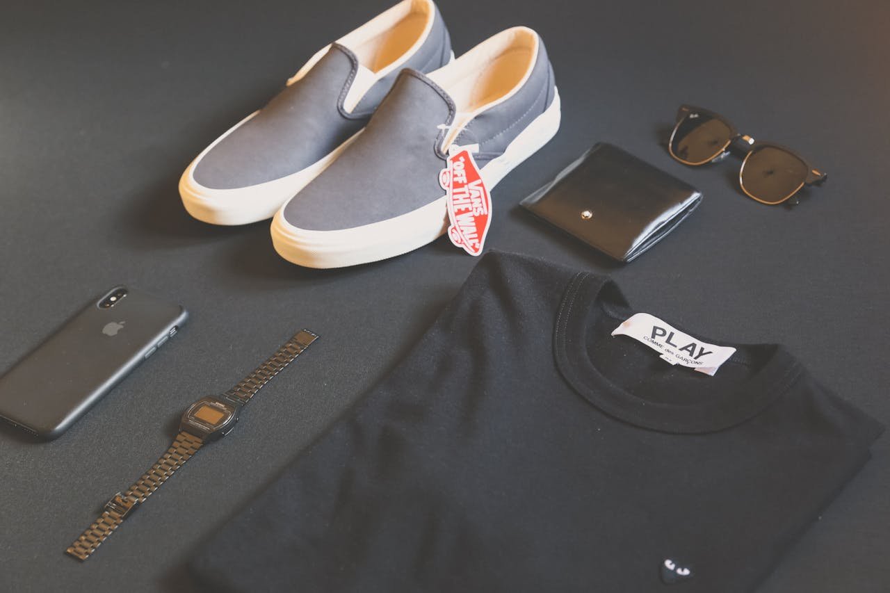 Pair of Gray Vans Low-top Sneakers Beside Black Shirt, Sunglasses, and Watch